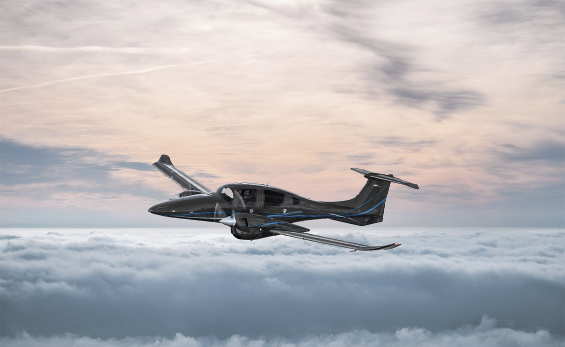 Diamond DA62 Propellerflugzeug im Flug Diamond DA62 zweimotoriges Propellerflugzeug im Flug über einer Wolkendecke bei Sonnenuntergang.