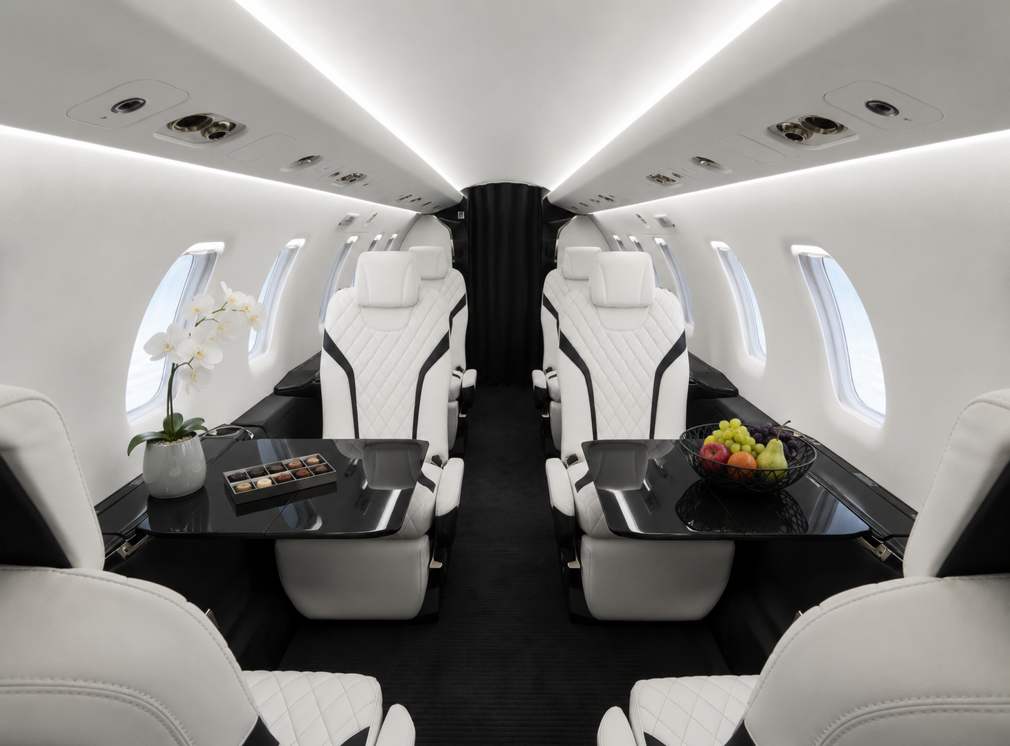 Luxuriöse Kabine einer Pilatus PC-24 mit weißen Ledersitzen, großzügigem Raumangebot und modernem Interieur.